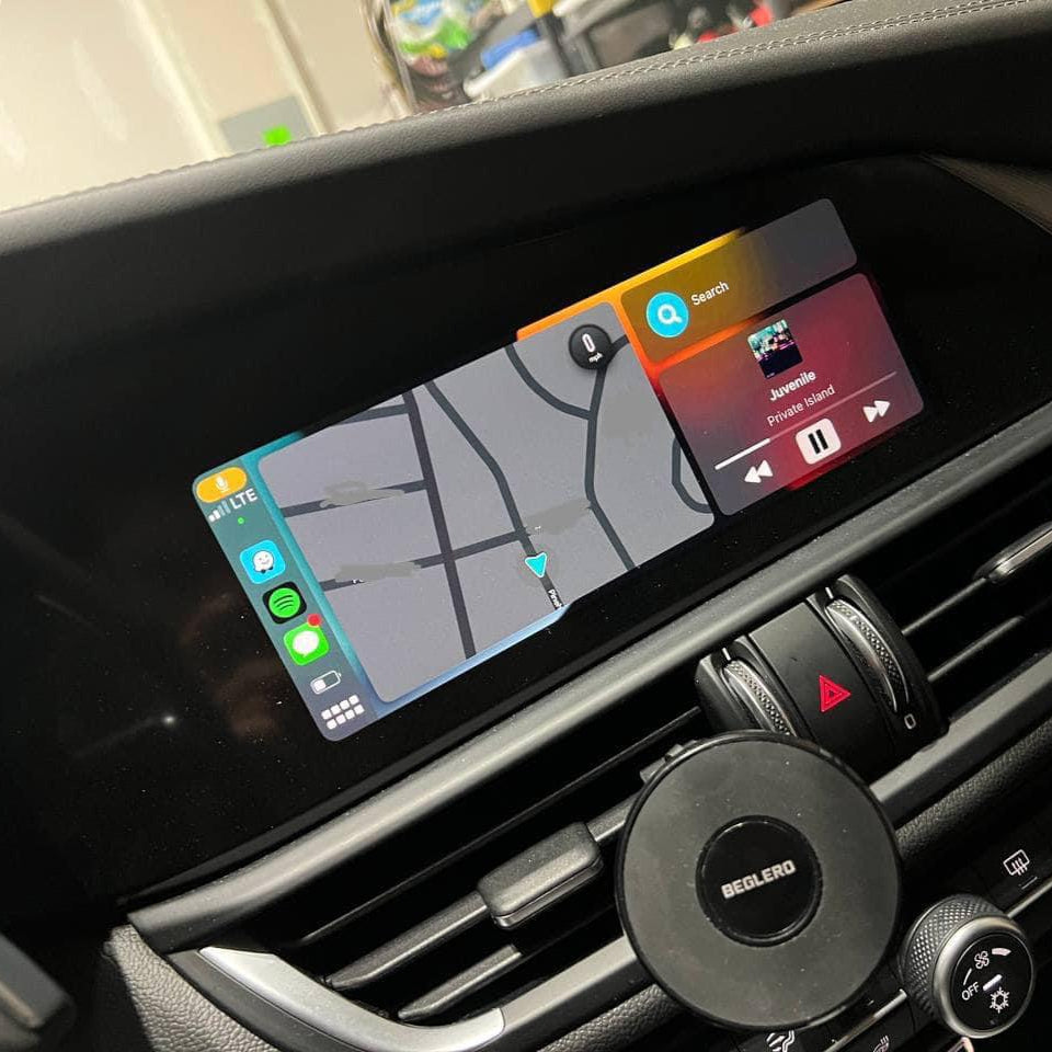 Alfa Romeo interior dashboard showing the integrated wireless Apple CarPlay navigation on the infotainment screen.